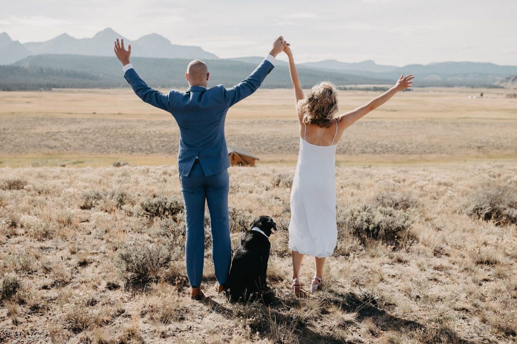 A bride and groom cheering before their elopement in the Sawtooth Mountains.