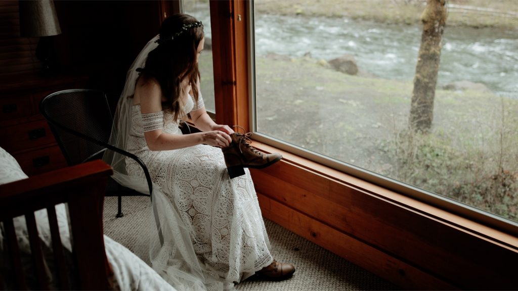 A bride putting on hiking boots before her Mt Hood elopement.