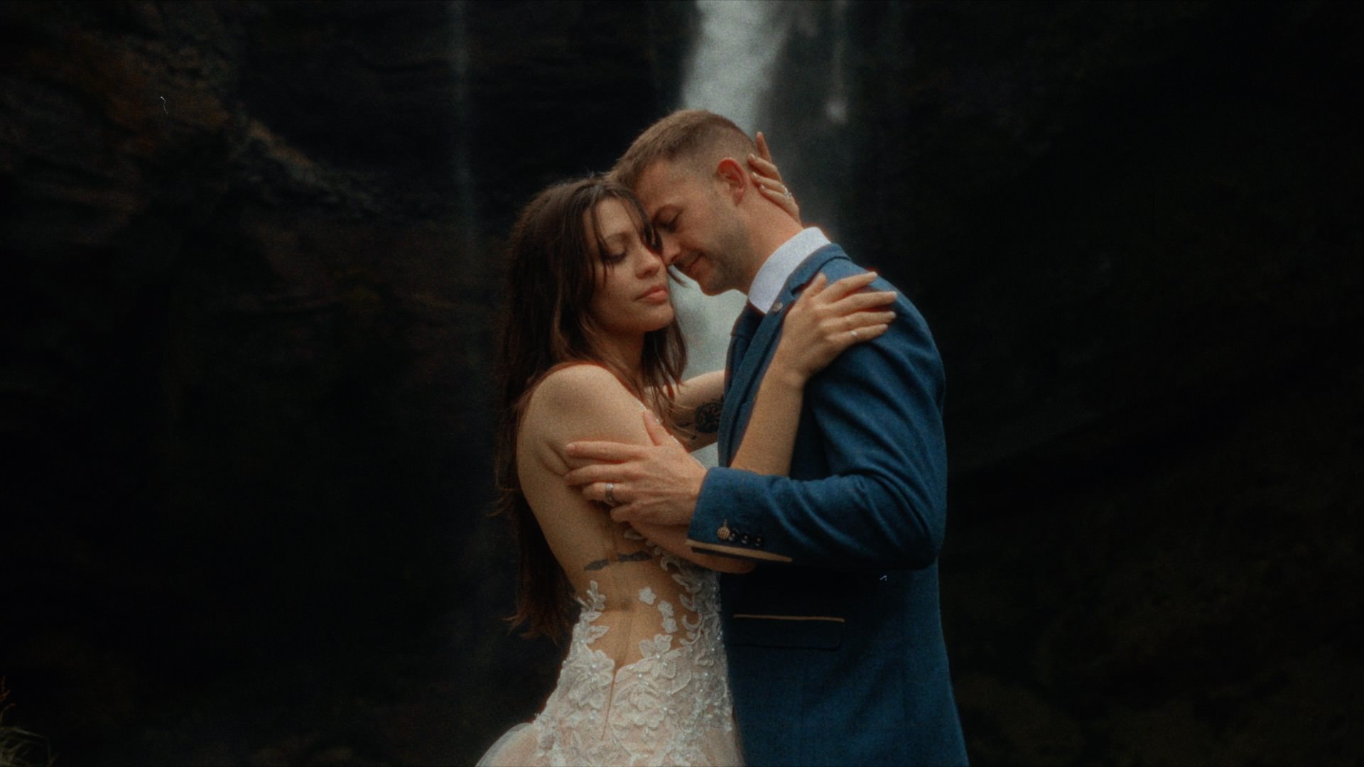 a couple embracing each other at a waterfall in iceland
