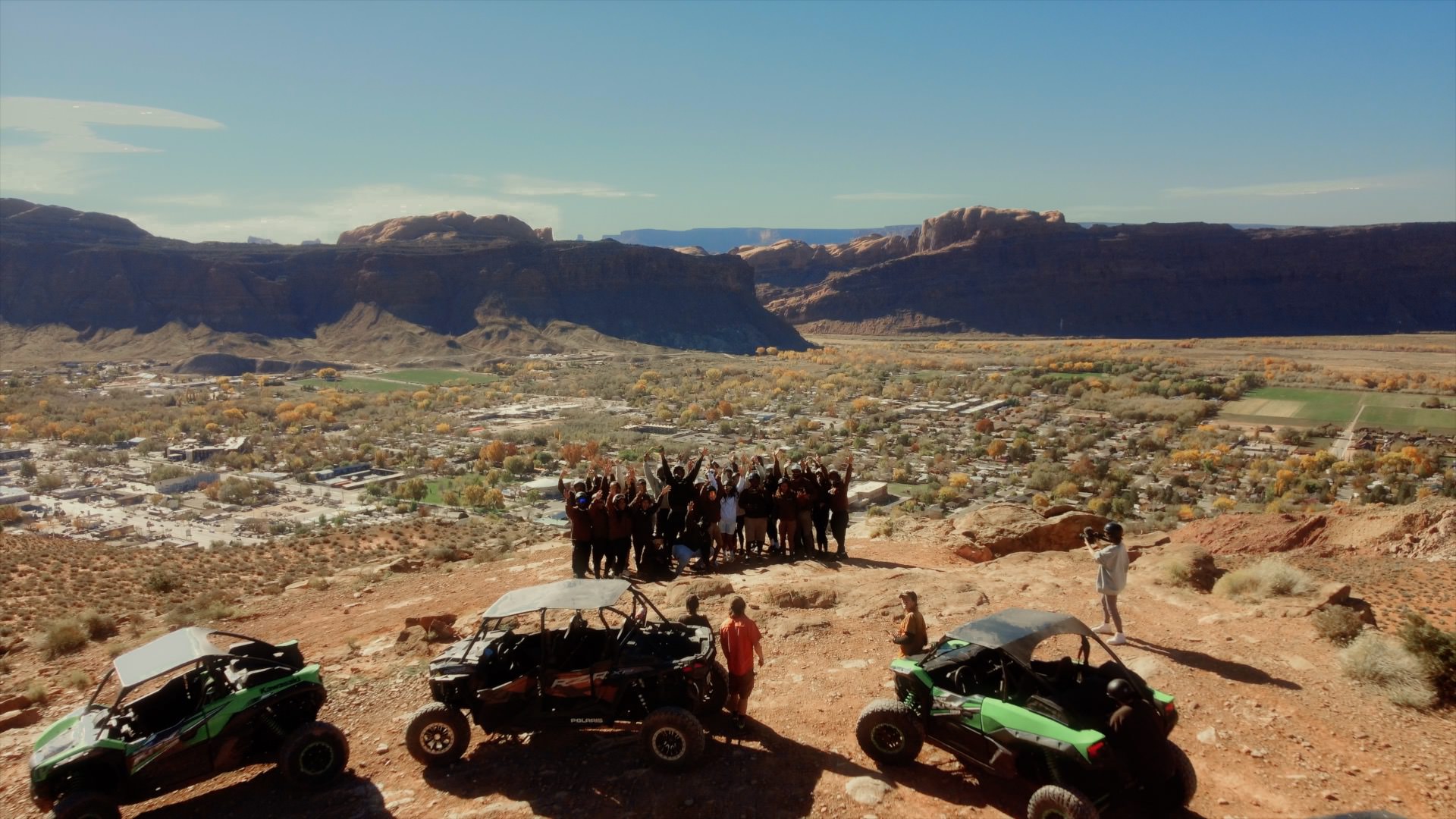 a group of friends at the top of a mountain in moab