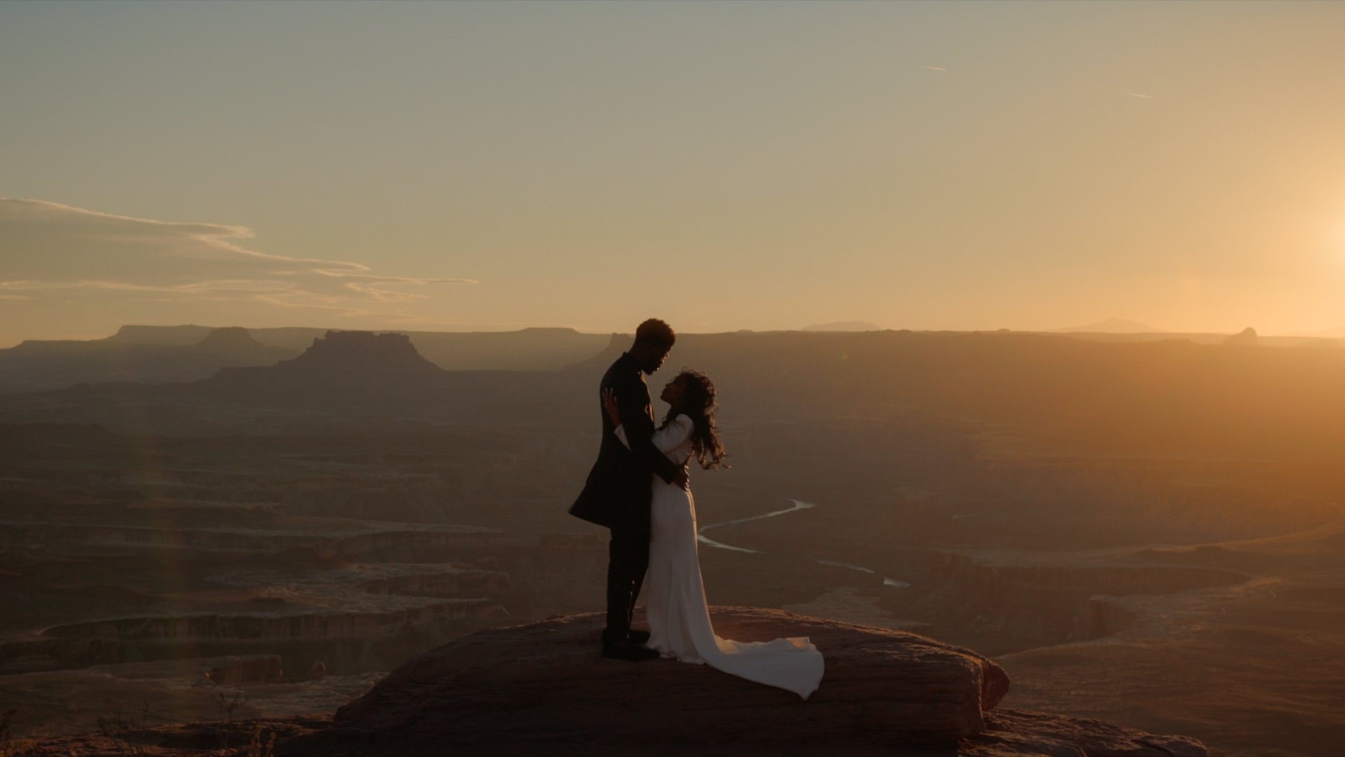 a man and woman holding each other at canyonlands national park