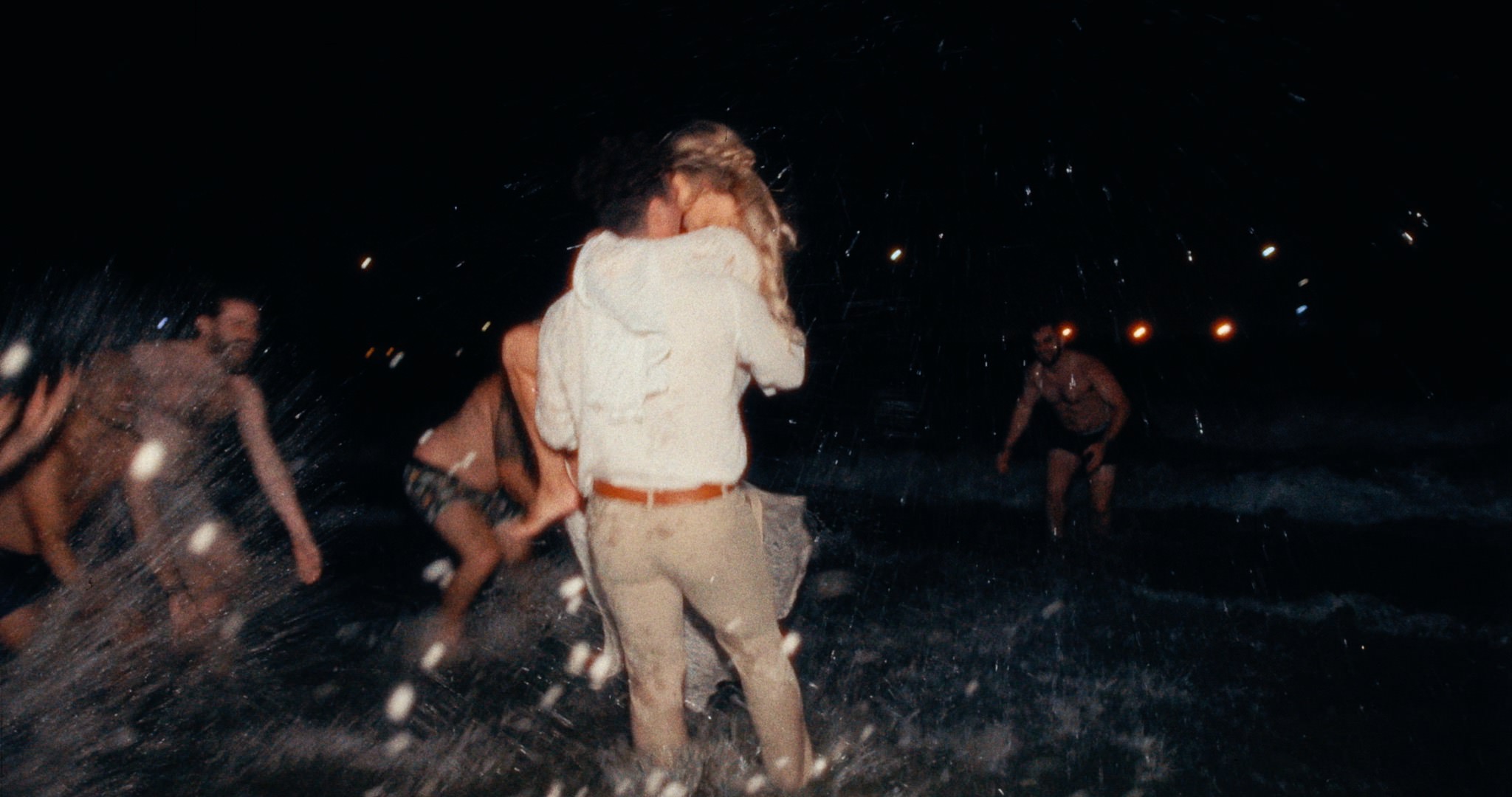 a couple running into the ocean at night after their wedding in Santa Barbara, ca